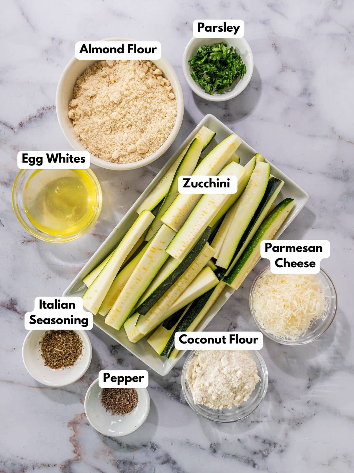 Ingredients to make crispy baked zucchini fries in bowls on a countertop.