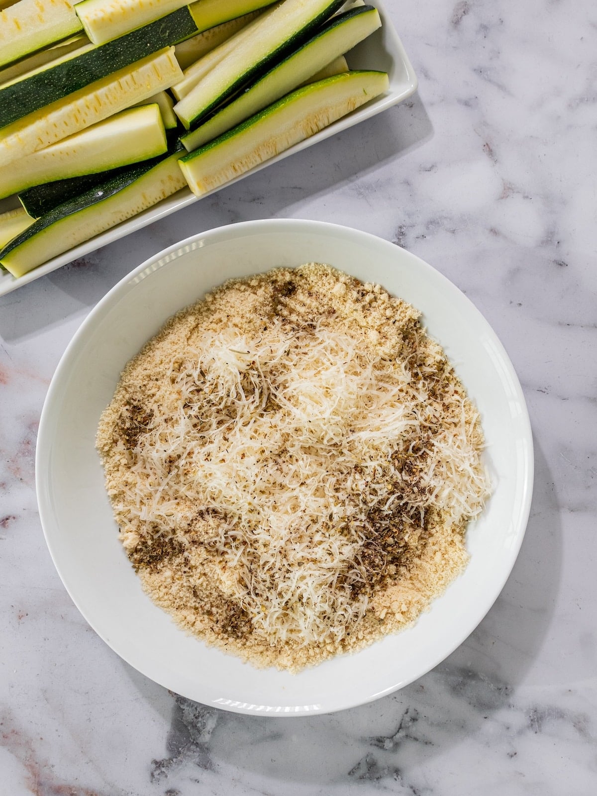 Ingredients to make the breading for baked zucchini sticks in a bowl.