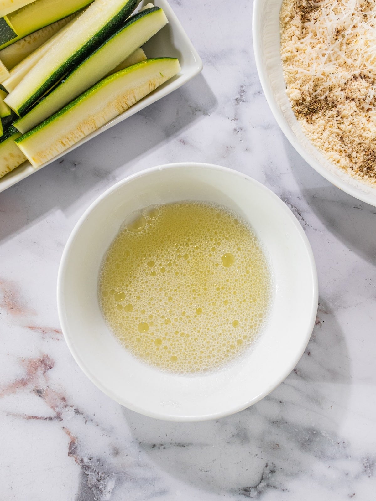 Egg whites and water whisked in a bowl.