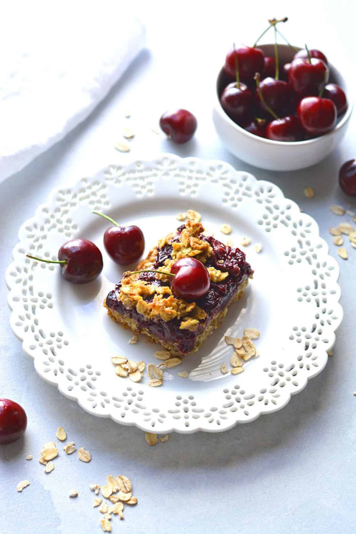 A plate with a piece of an oatmeal cherry bar on a plate.
