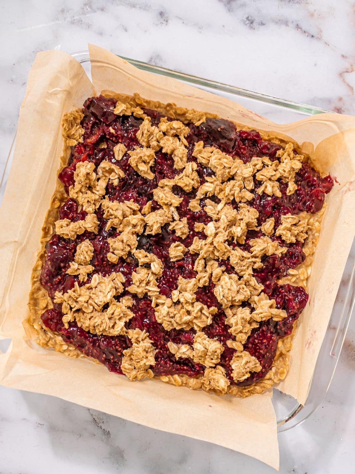 The mixture added to the baking dish with the cherrie filling on it.