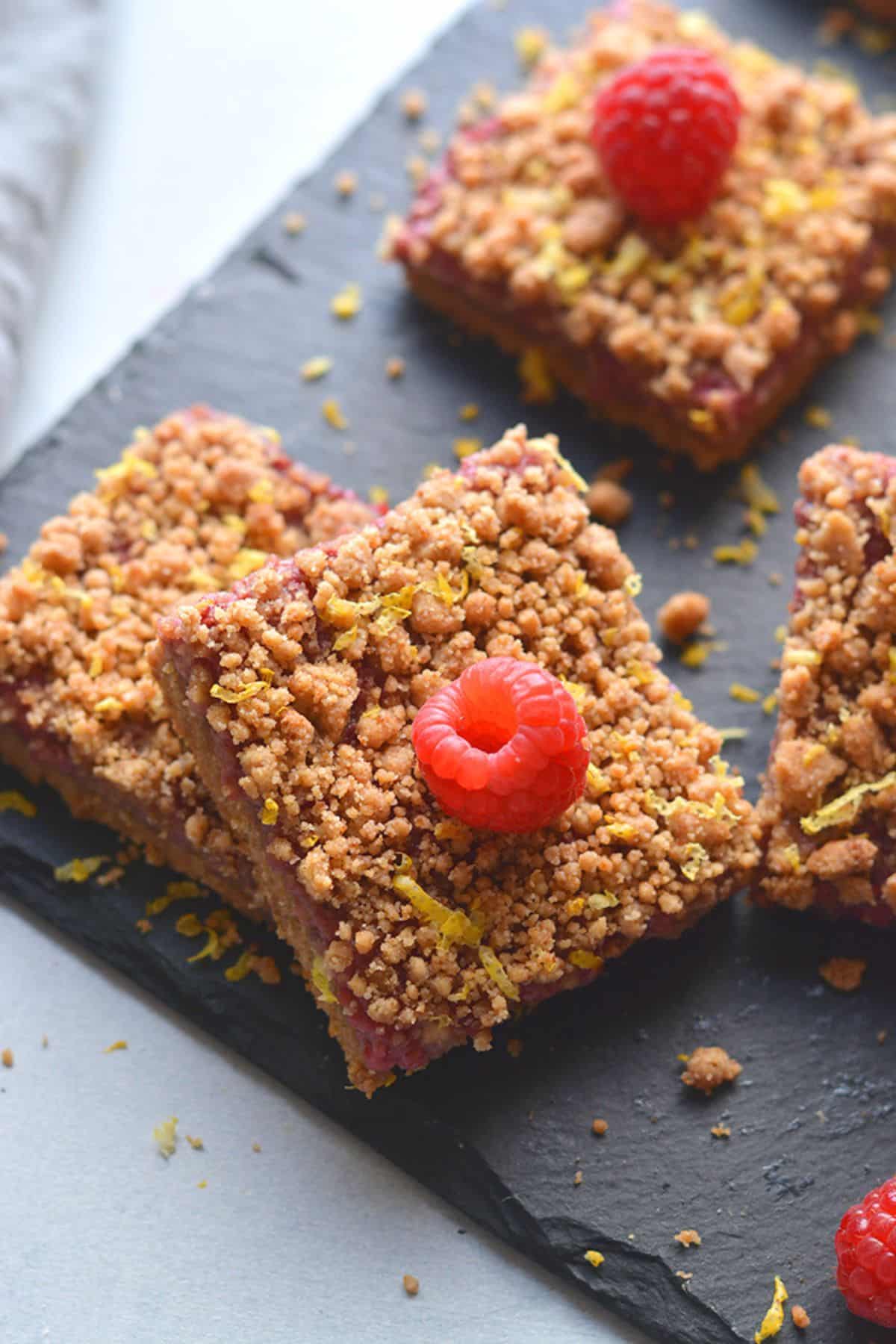 A square of raspberry bars leaning on another bar.