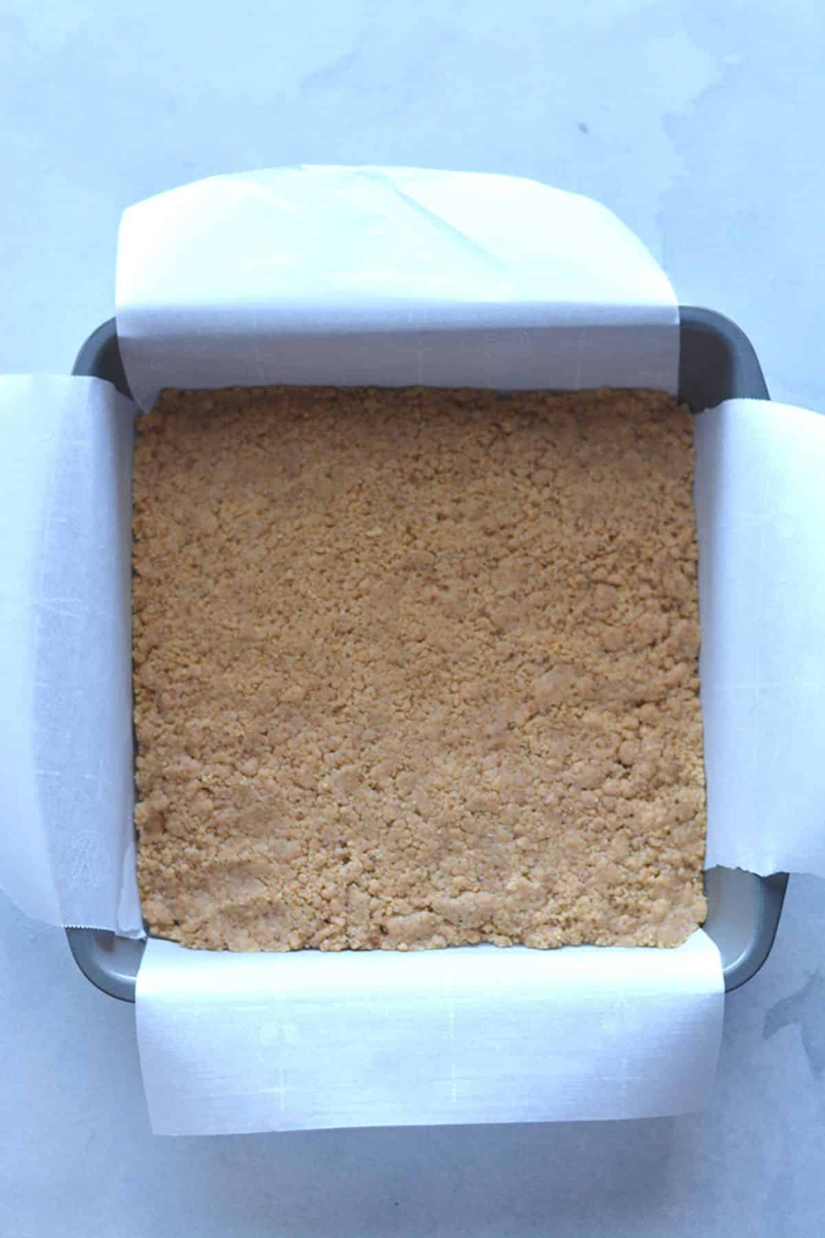 The wet and dry mixture combined then pressed into a baking pan.