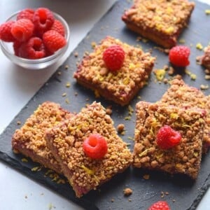 Gluten free raspberry bars cut up on a cutting board.