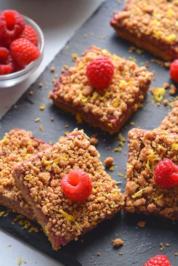 Gluten free raspberry bars cut up on a cutting board.