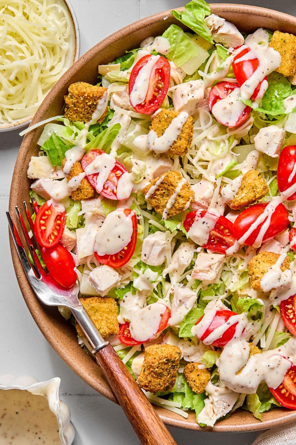 Caesar salad with croutons and dressing on top.