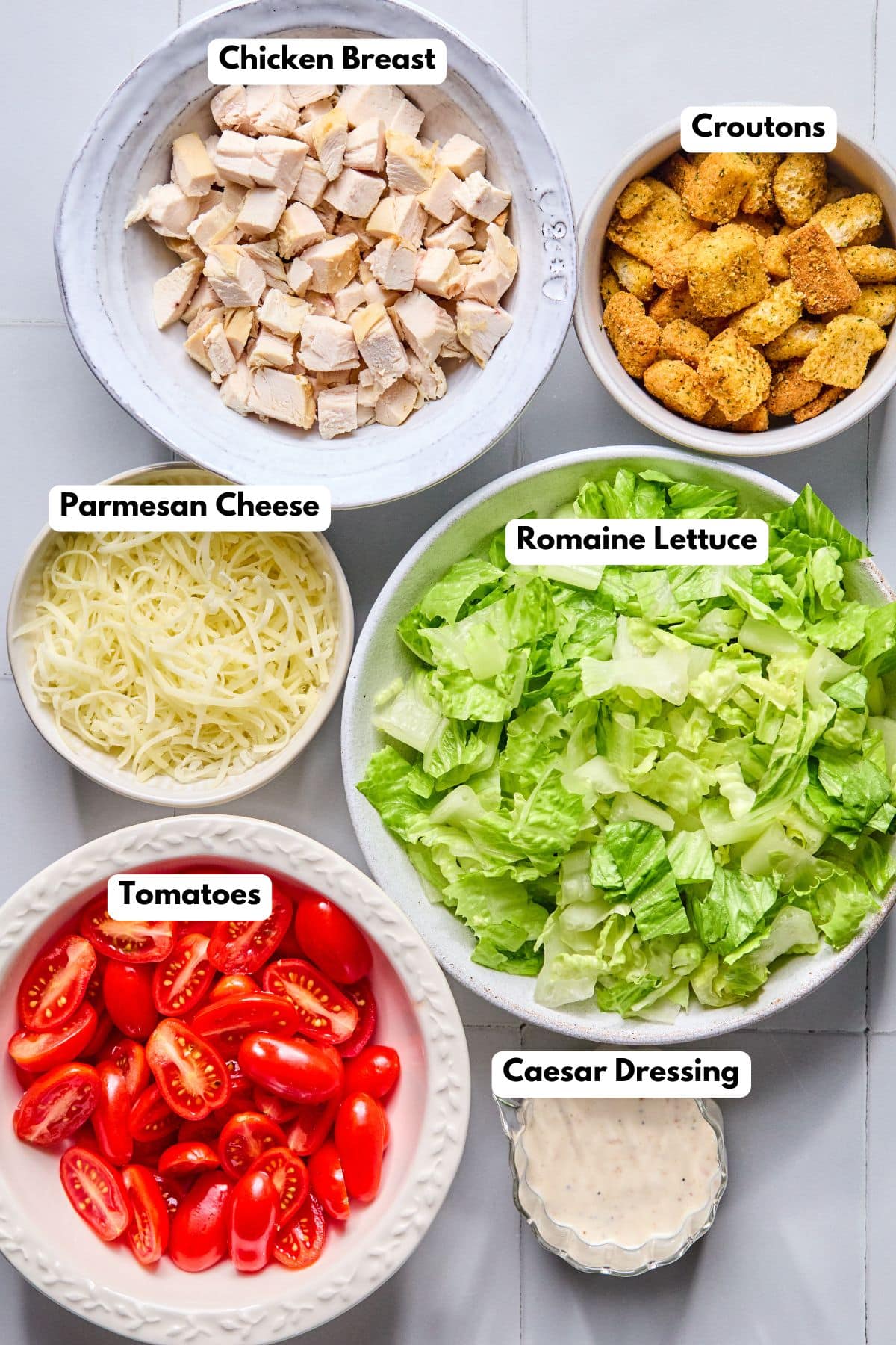 Ingredients to make a low-calorie Caesar salad in bowls on a table.