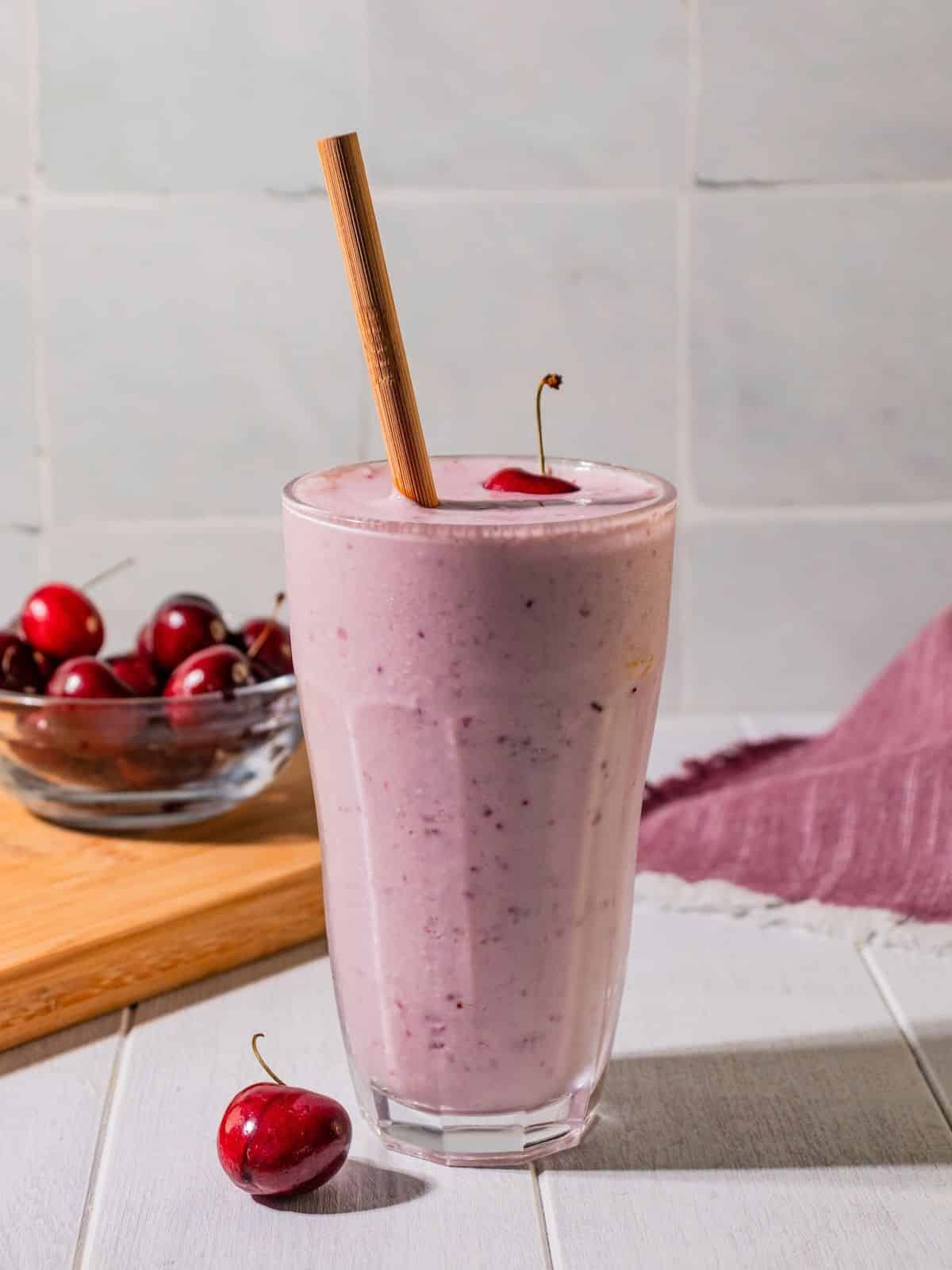 Cherry smoothie with a straw in it.