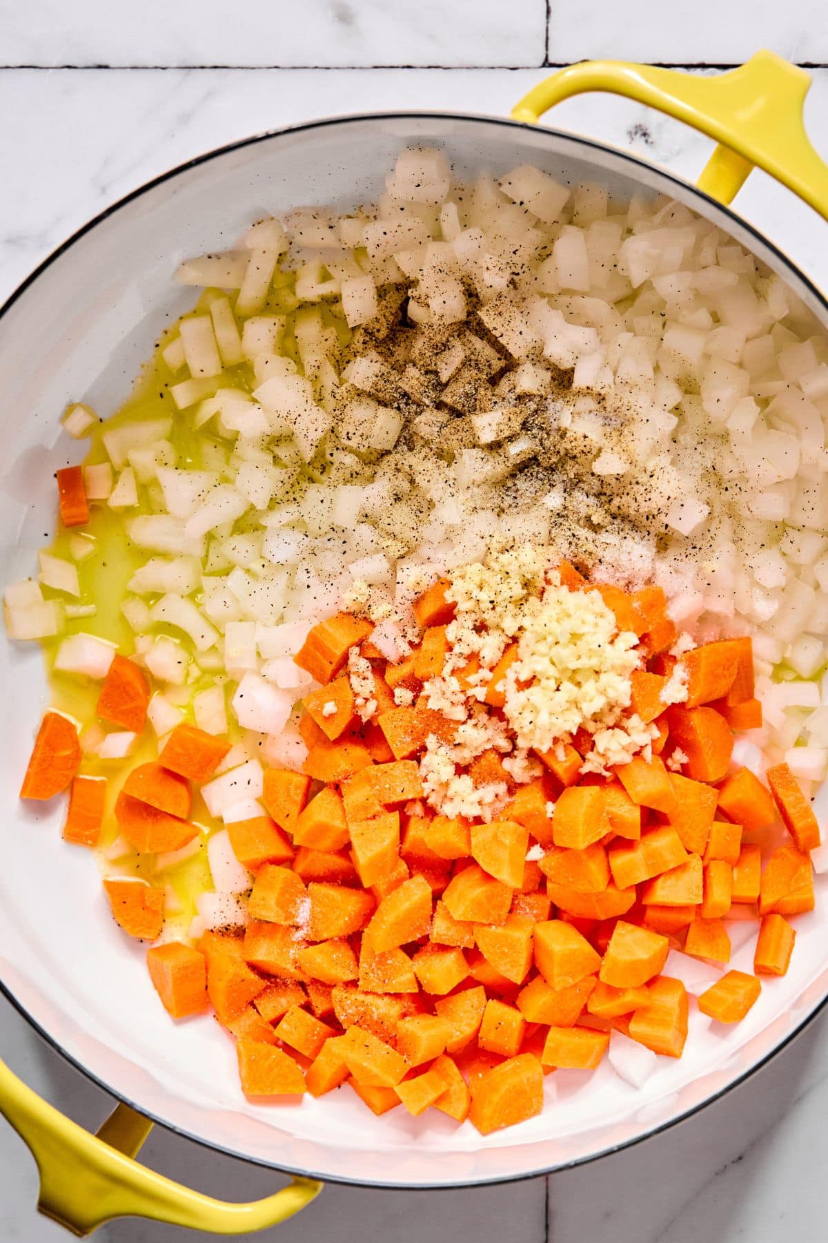 Carrots, onions and garlic cooking in a pot .
