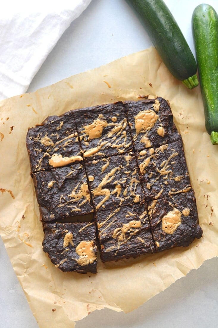 Zucchini brownies cut up on parchment paper.
