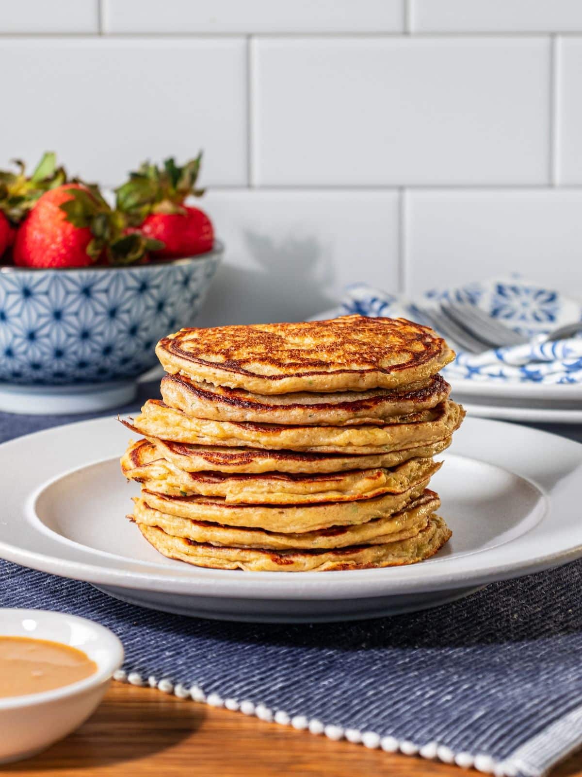 Healthy zucchini pancakes stacked on a plate.