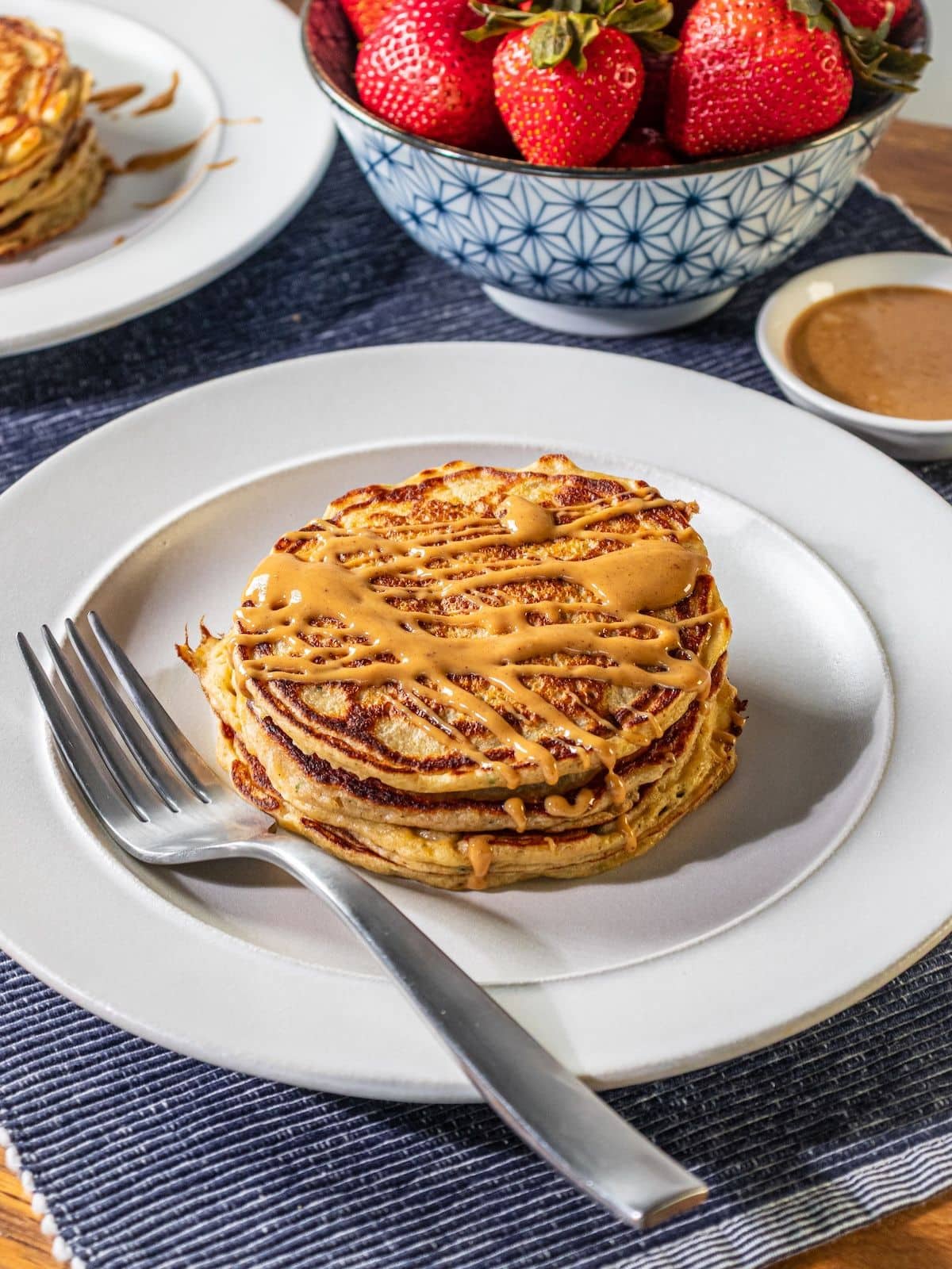Zucchini pancakes with peanut butter on top.