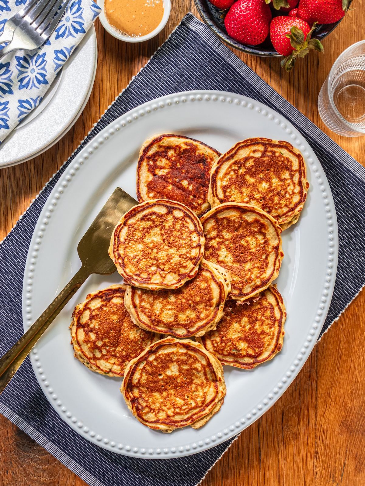 A platter dish with zucchini pancakes on it.