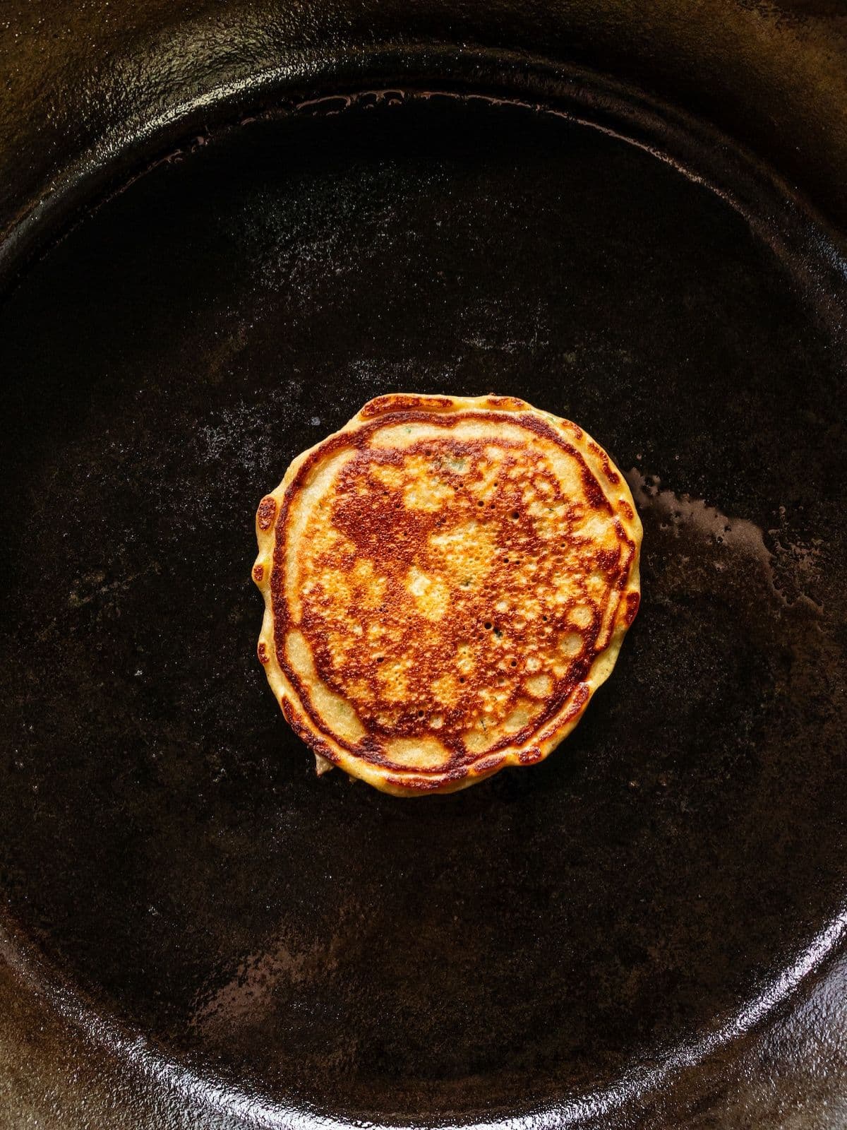A pancake cooking on the pan.