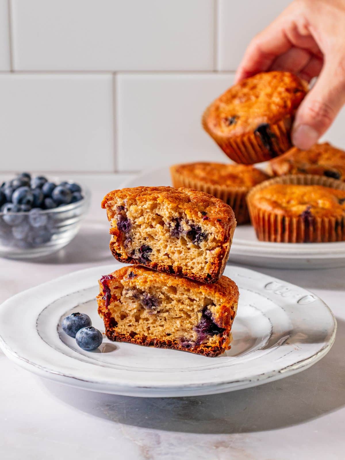 Two halfs of a blueberry muffin on a plate.