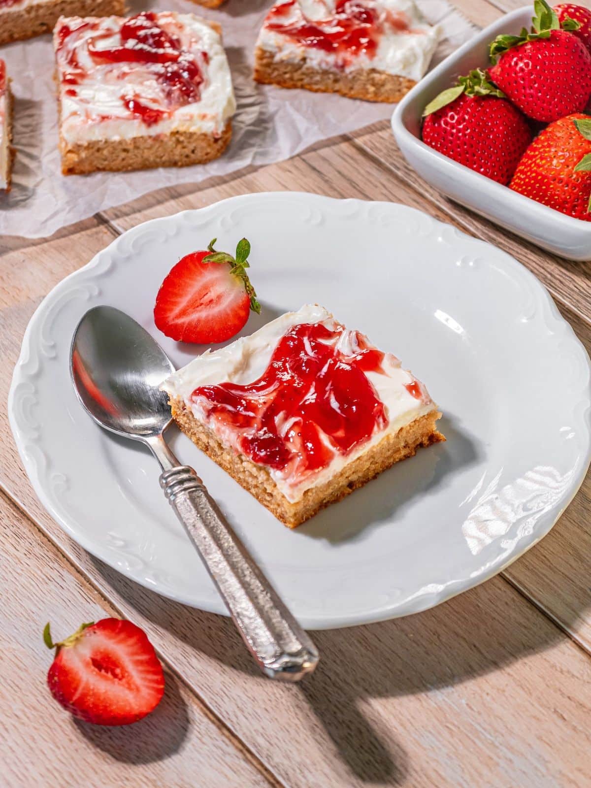 A slice of strawberry cheesecake bar on a plate.