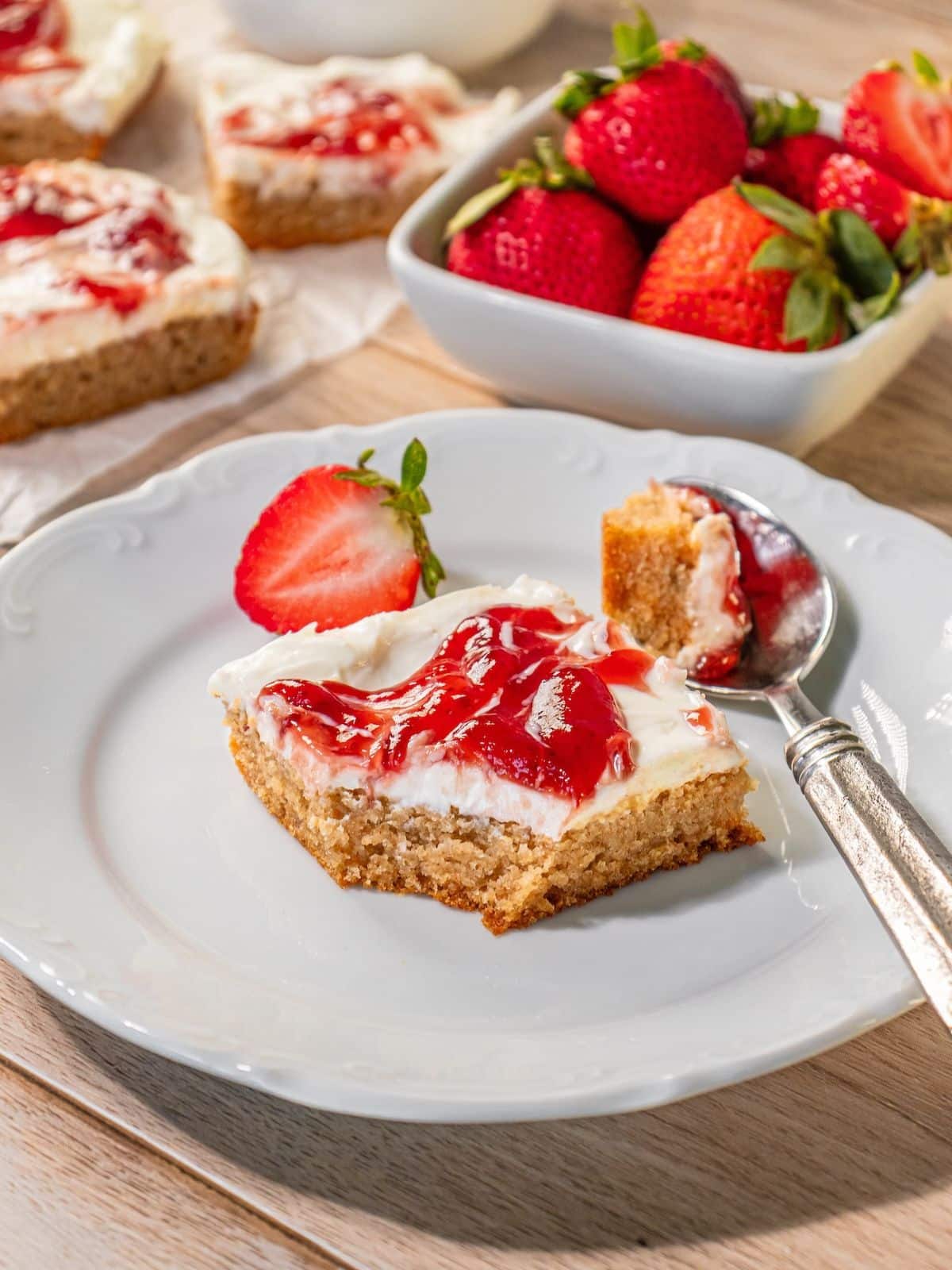 Strawberry cheesecake bars with a piece taken out.