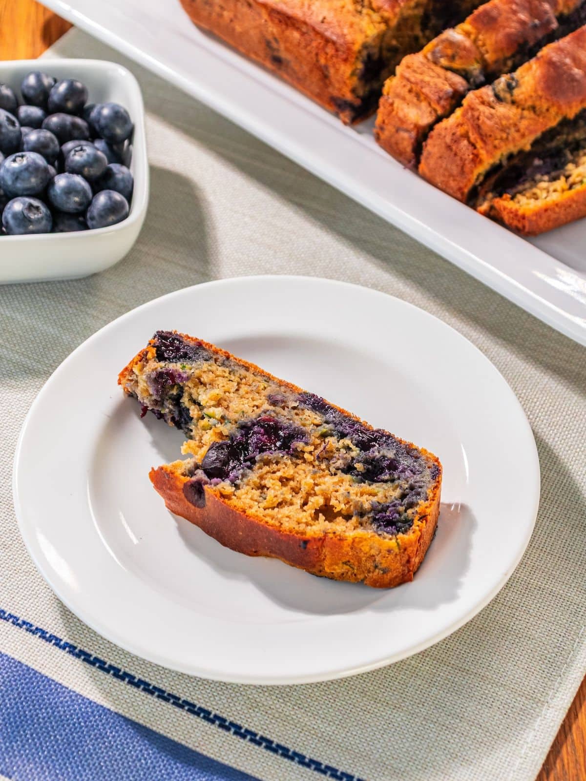 A bite taken out of zucchini bread on a plate.