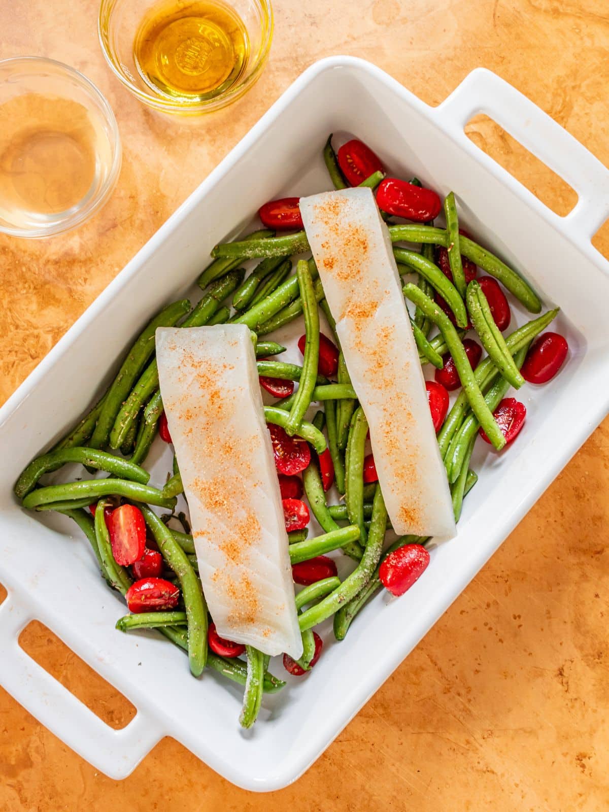 Slices of halibut over green beans and tomatoes.