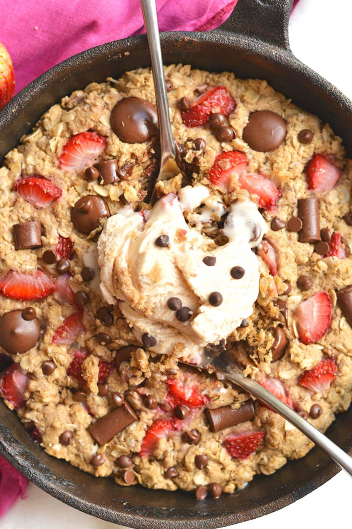 Spoons scooping out some cookie from a skillet.