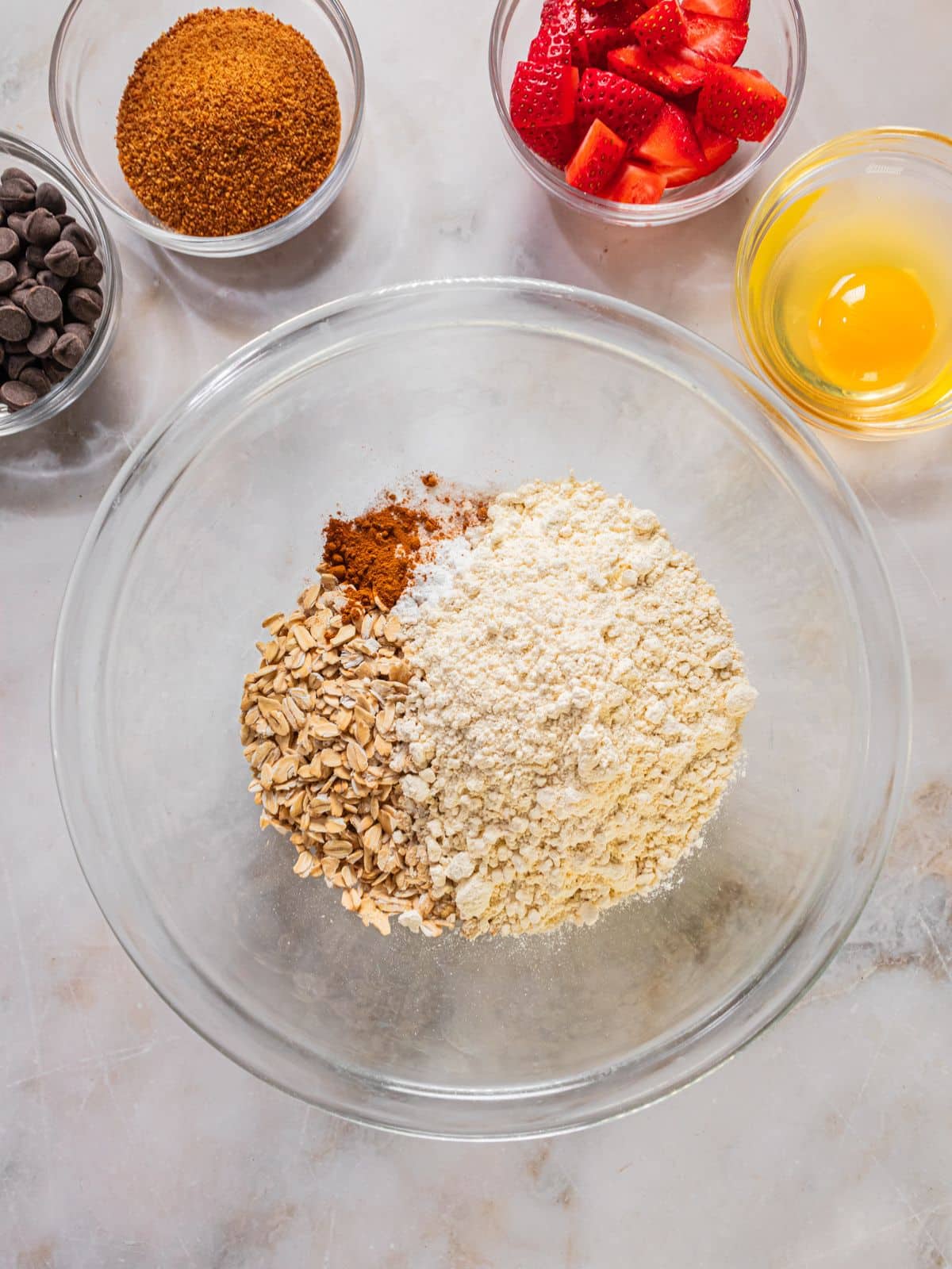 Flour, oats, cinnamon, baking soda and baking powder in a bowl.