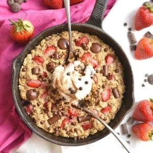 Gluten free skillet cookie with spoons scooping out some.
