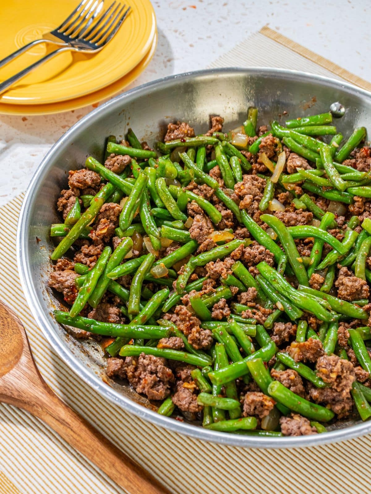 Ground beef and green beans in a pan.