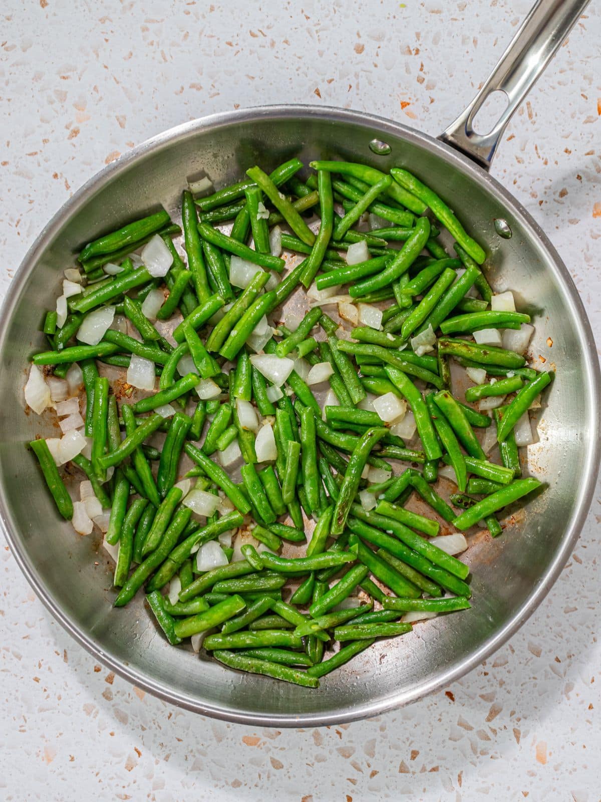 Green beans and onions in a pan.