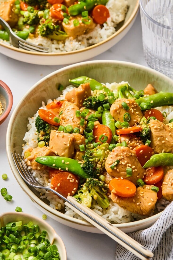A bowl filled with rice and chicken teriyaki.