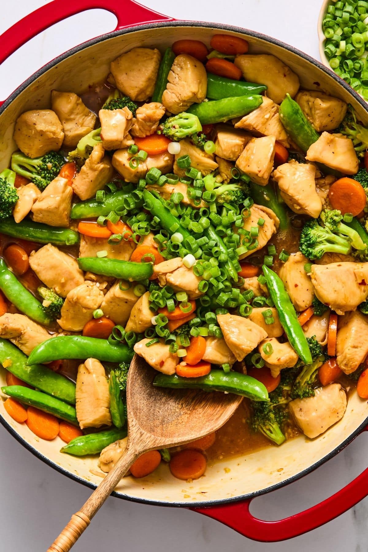 The sauce and green onions added to the chicken and veggies.