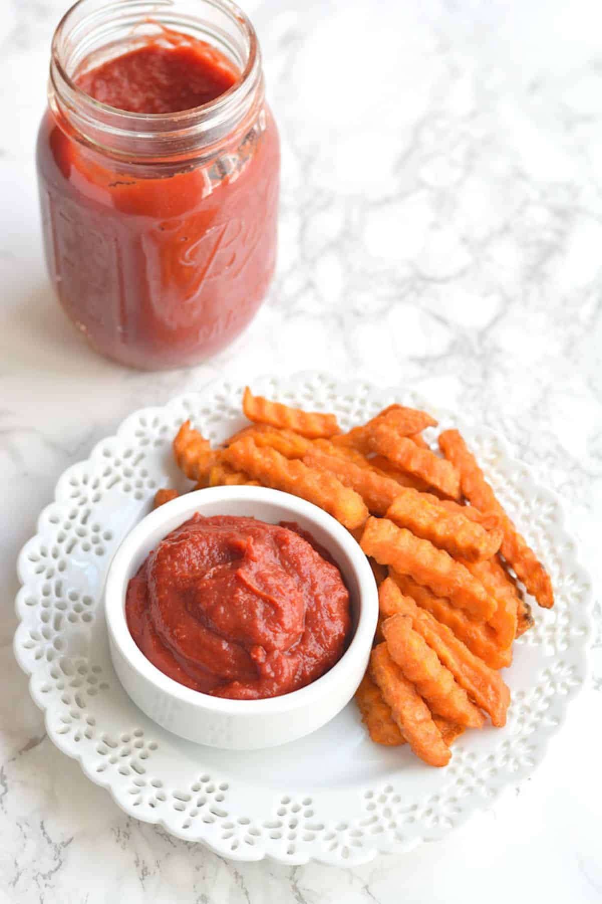 Homemade ketchup with tomato paste on a plate with french fries.