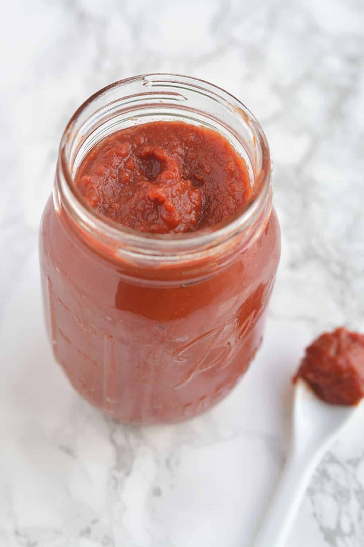 Healthy homemade ketchup in a mason jar.