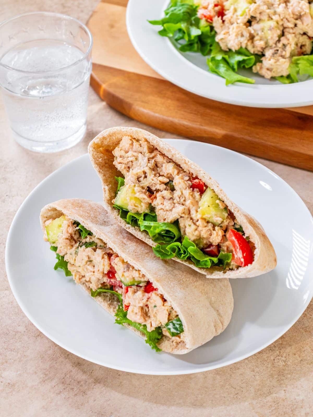 A pita sandwich filled with tuna salad with hummus.