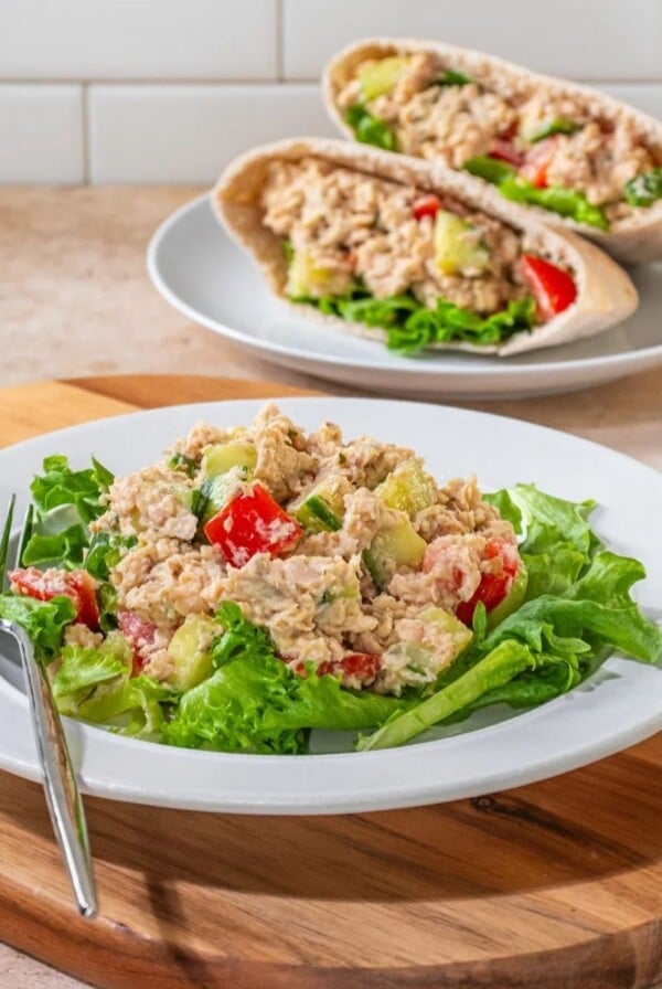 Hummus tuna salad on a plate with a sandwich in the back.