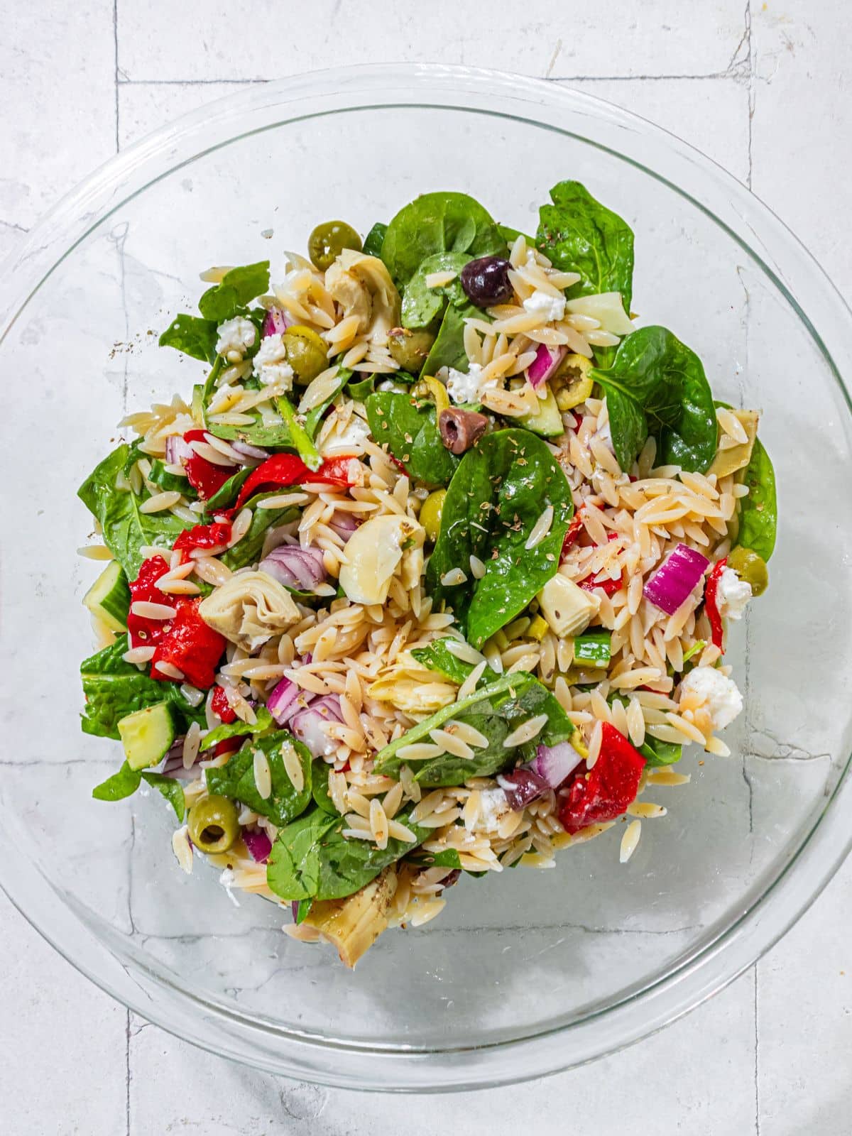 The oil, salt pepper and oregano added to the salad and mixed.