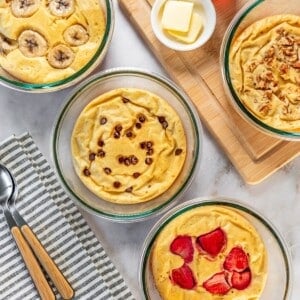 Four protein pancake bowls on a table each topped with a different topping.