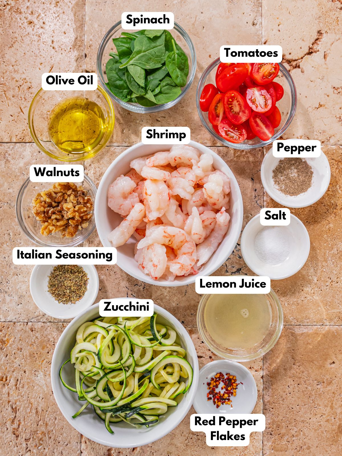 Ingredients to make this pesto shrimp dish in bowls on a table.