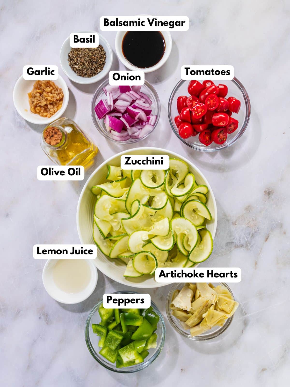 Ingredients to make this zucchini salad in bowls on a table.