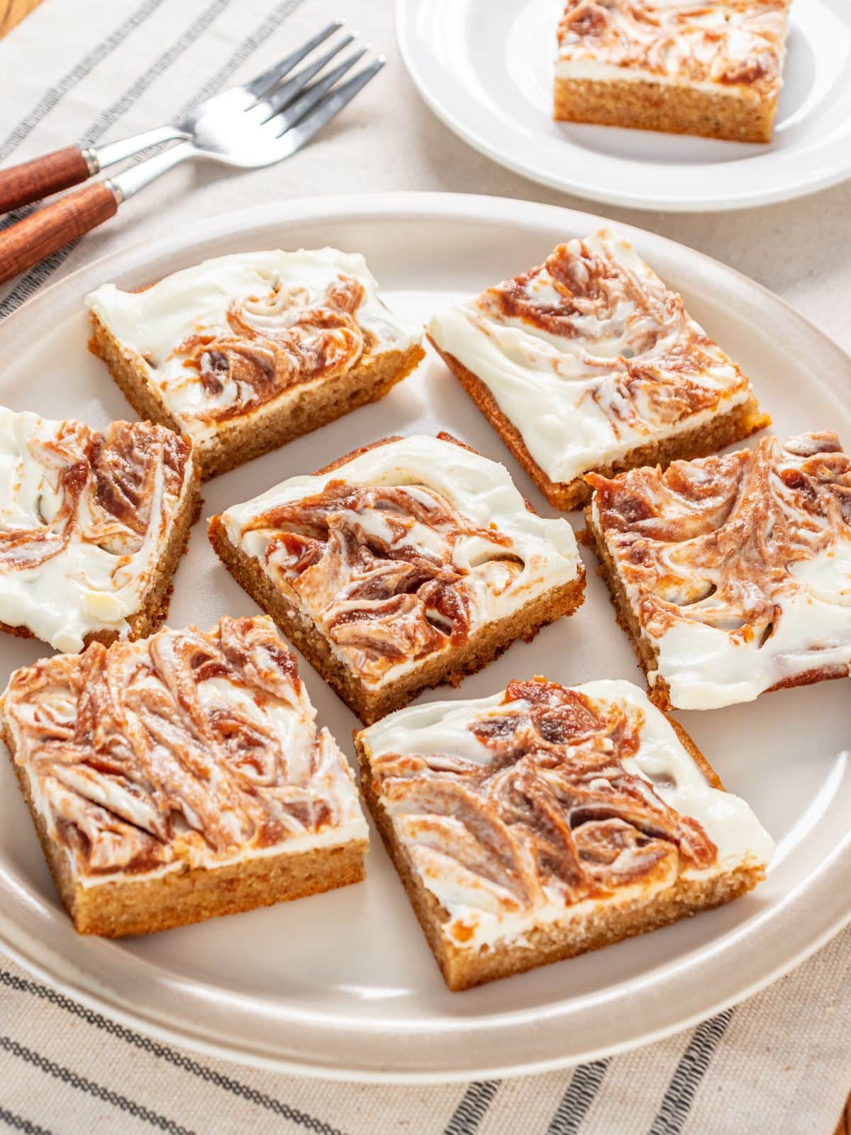 Apple cheesecake bars cut on on a plate.