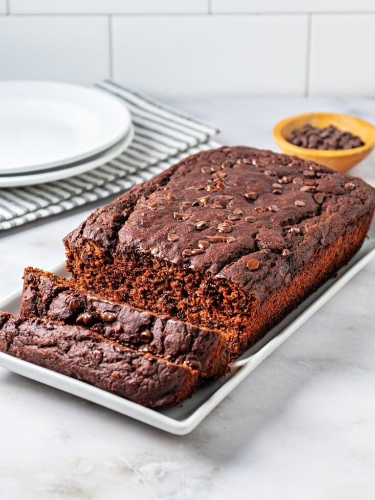 Butternut squash bread on a platter with a couple of slices cut and leaning over.