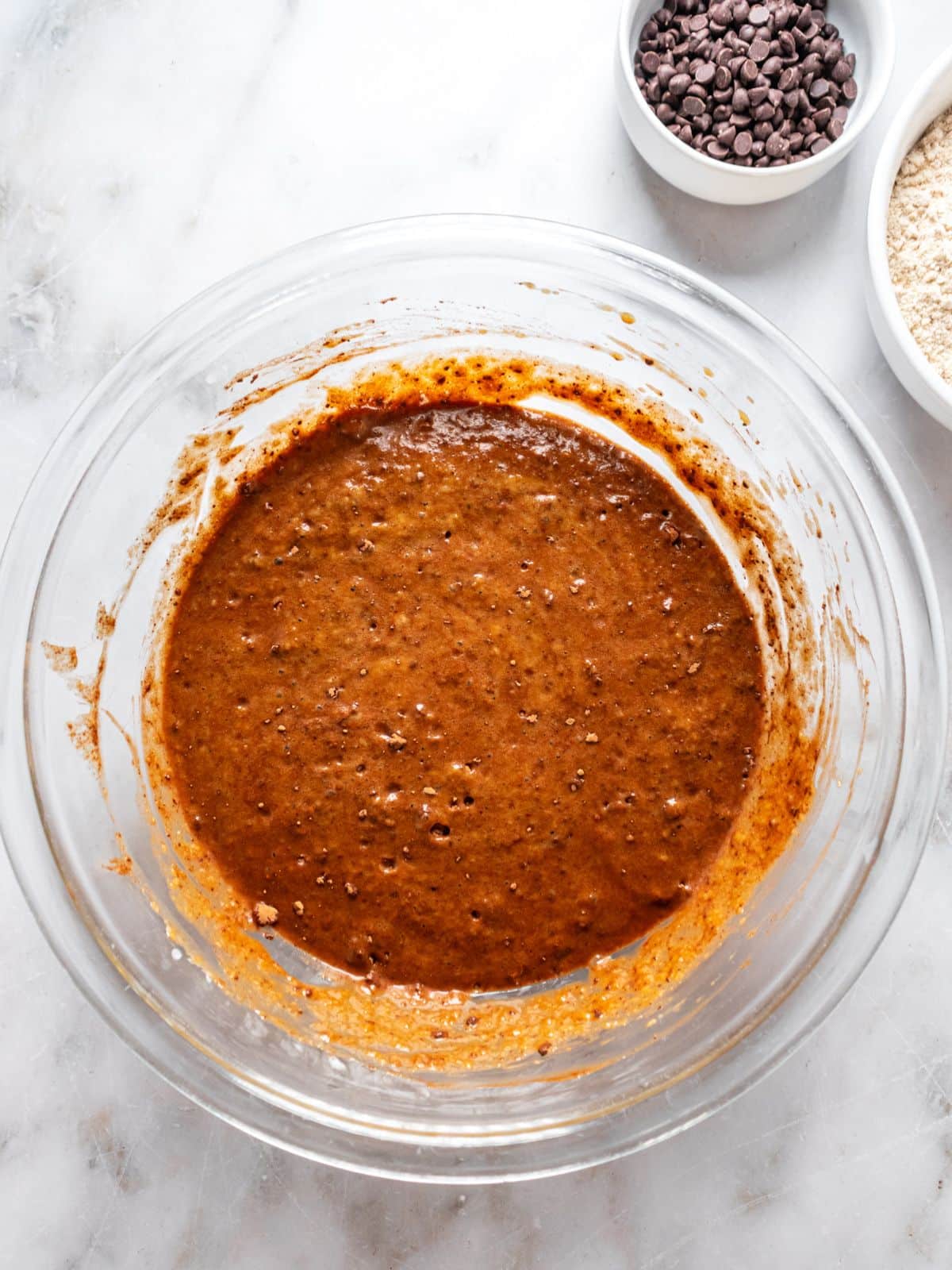 Butternut squash, almond extract, sea salt, baking soda, baking powder and cocoa powder added to the bowl.
