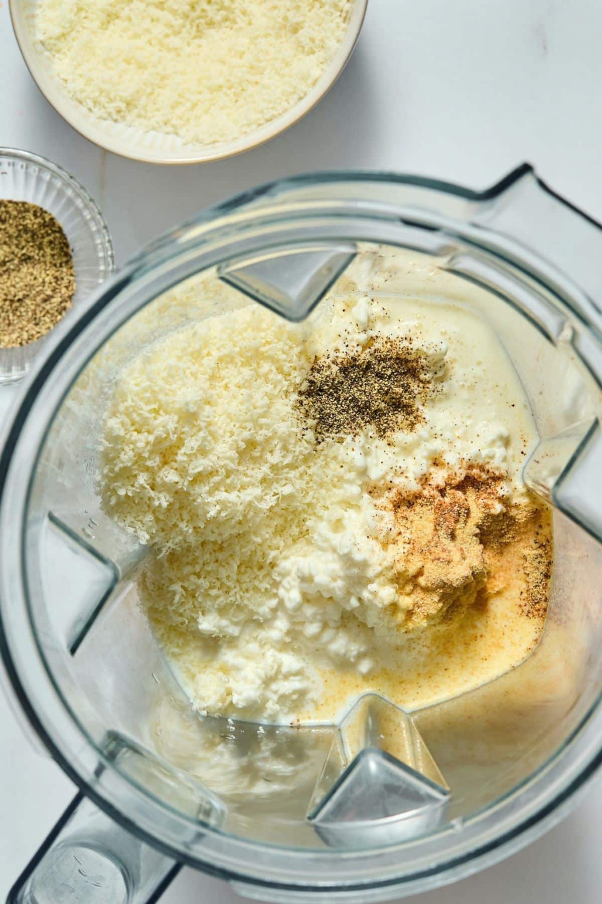 Cottage cheese, milk, parmesan, garlic powder, nutmeg, and pepper in a blender.