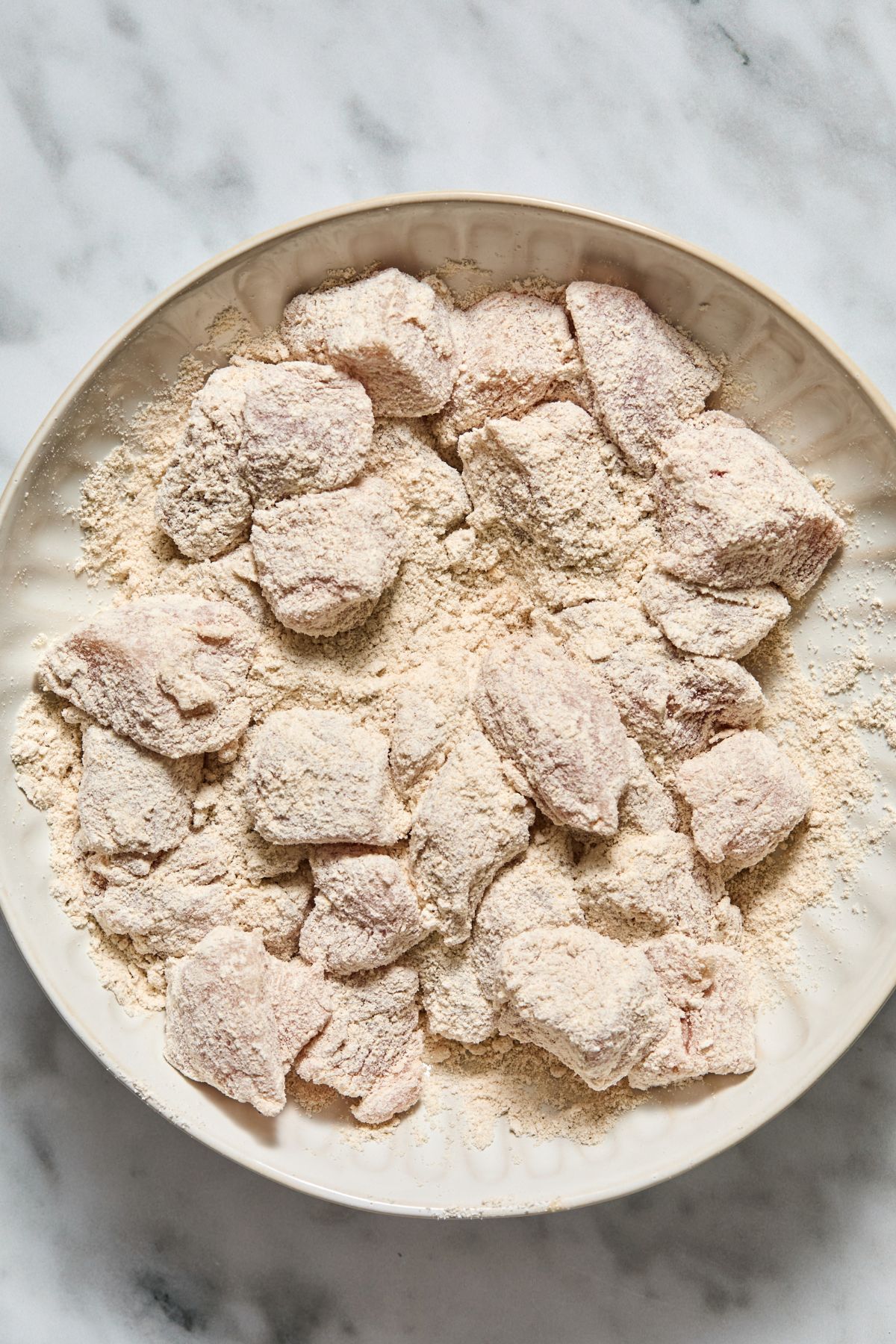 The chicken coated in the flour.