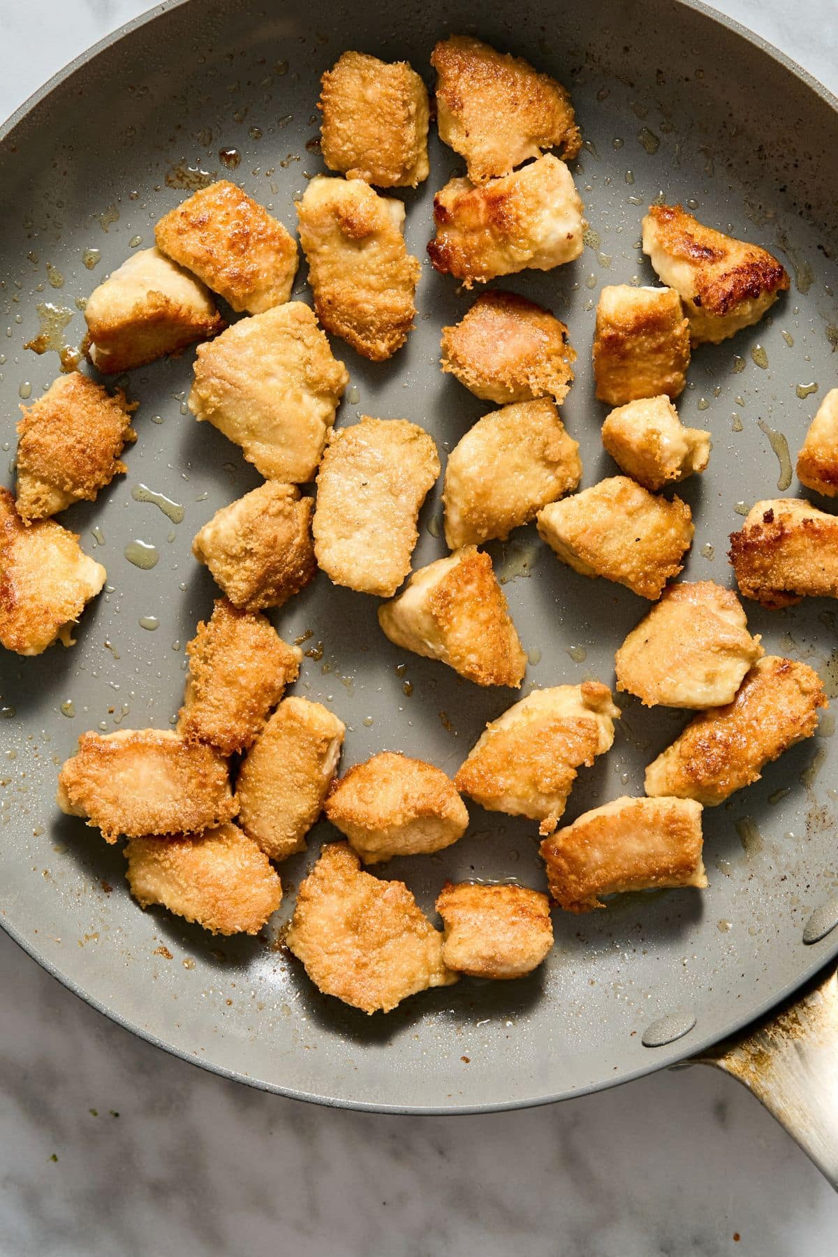 The chicken cooking on a skillet.