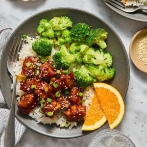 Healthy orange chicken with broccoli on the side.