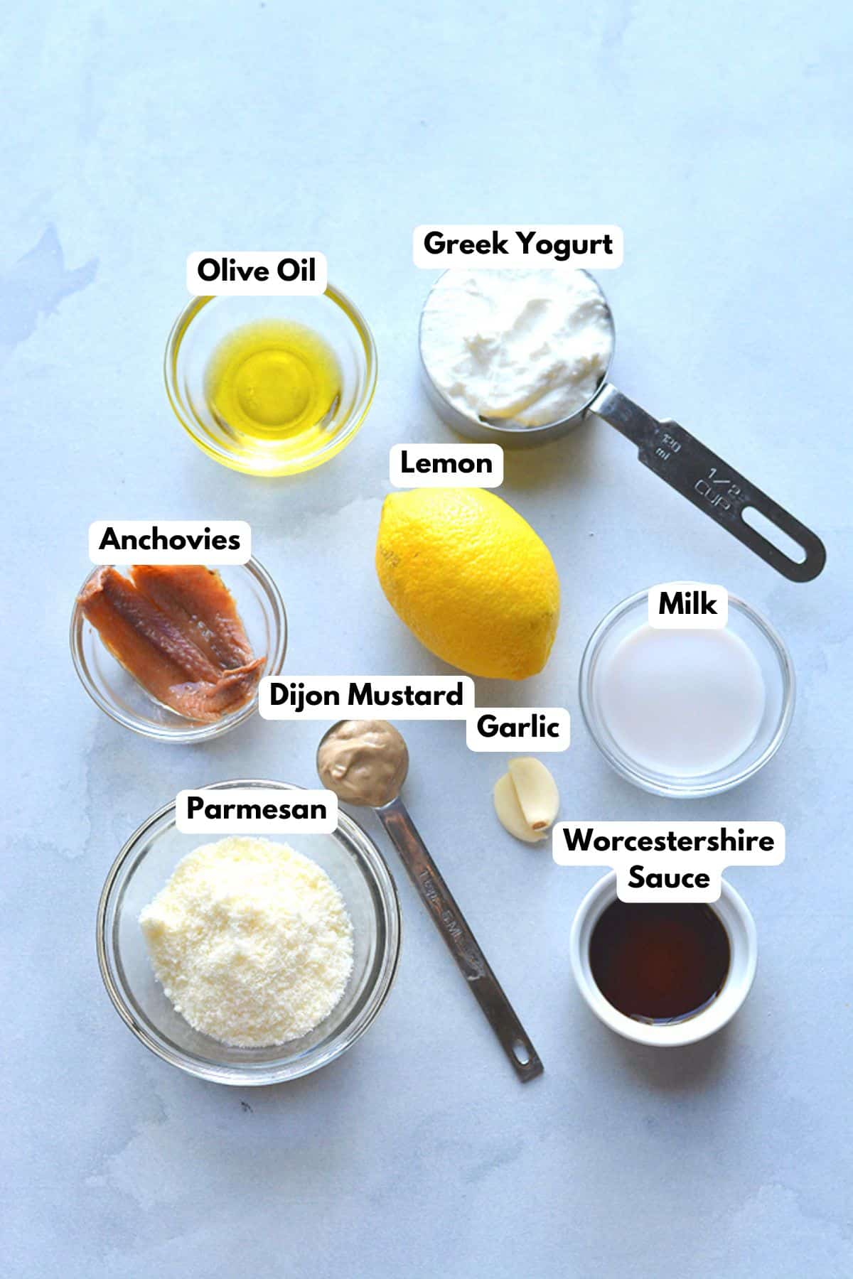 Ingredients to make a low calorie Caesar dressing on a table.