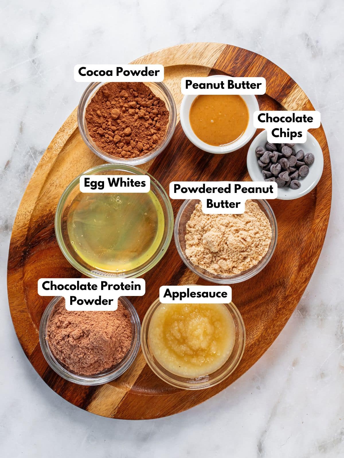 Ingredients to make these protein mug cakes in bowls on a cutting board.