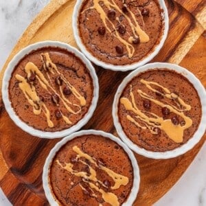 Protein mug cakes with peanut butter drizzle and chocolate chips.
