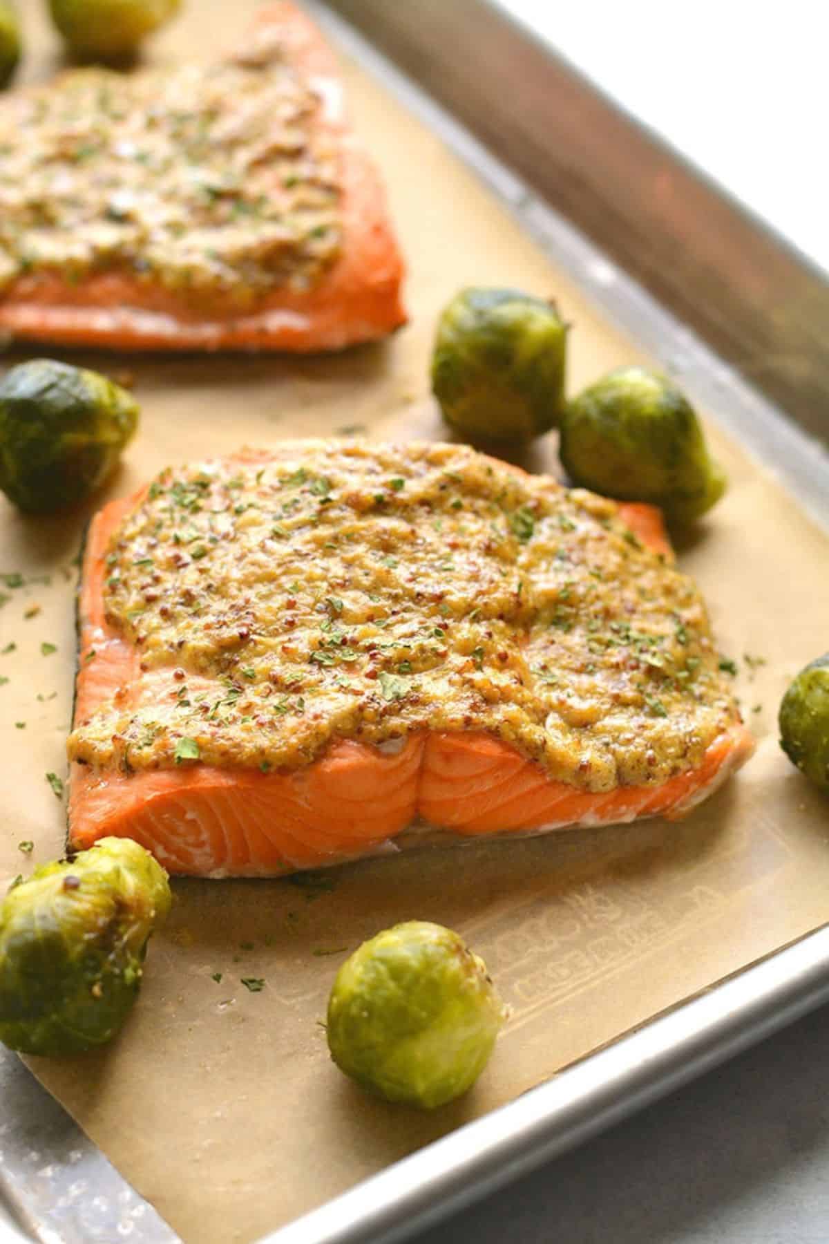 Salmon with mustard sauce on top on a tray.