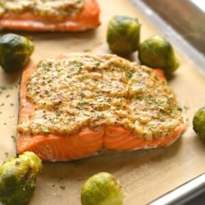 Air fryer salmon on a tray with mustard sauce on top.